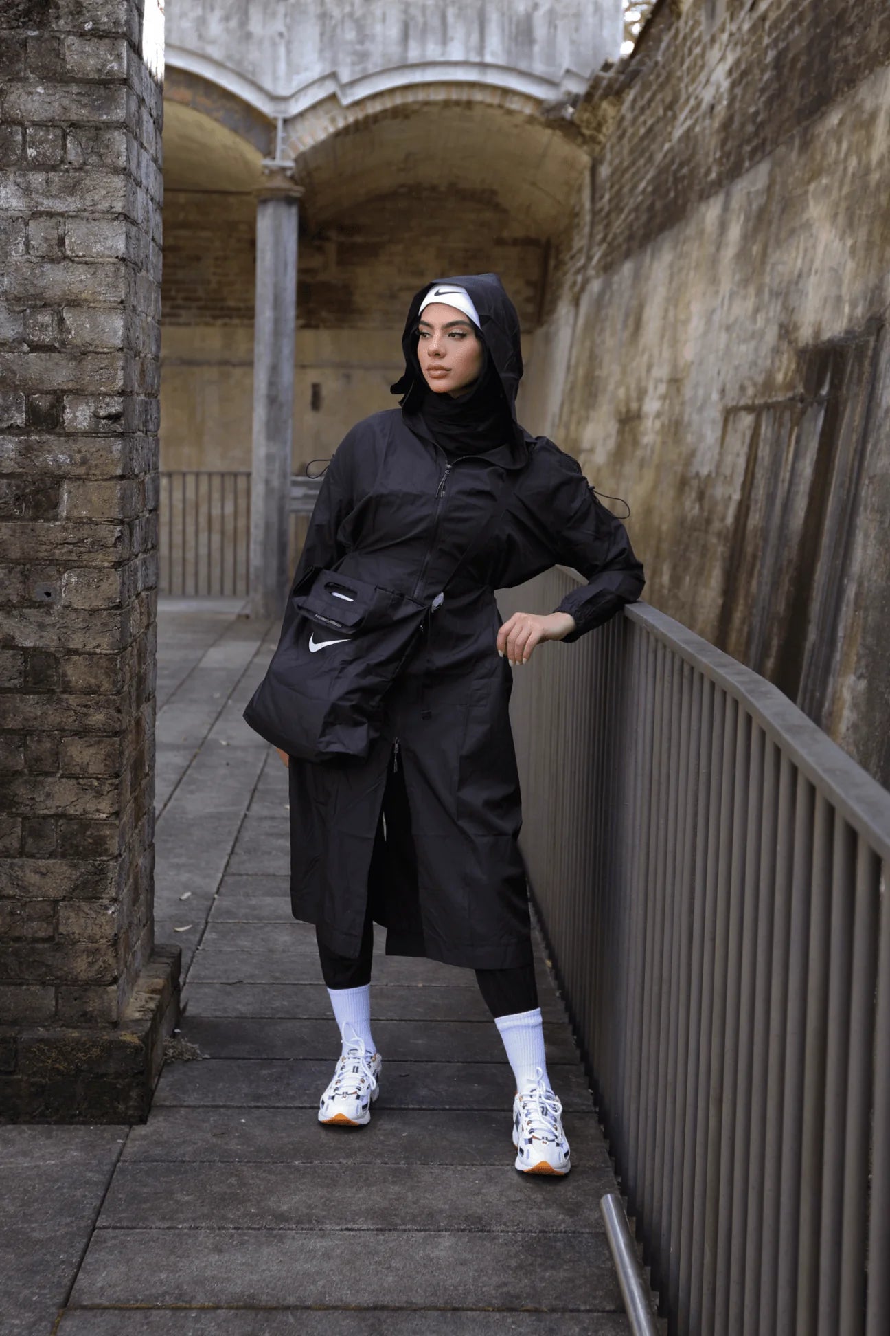 Person wearing a black outfit with a Nike logo in an urban setting