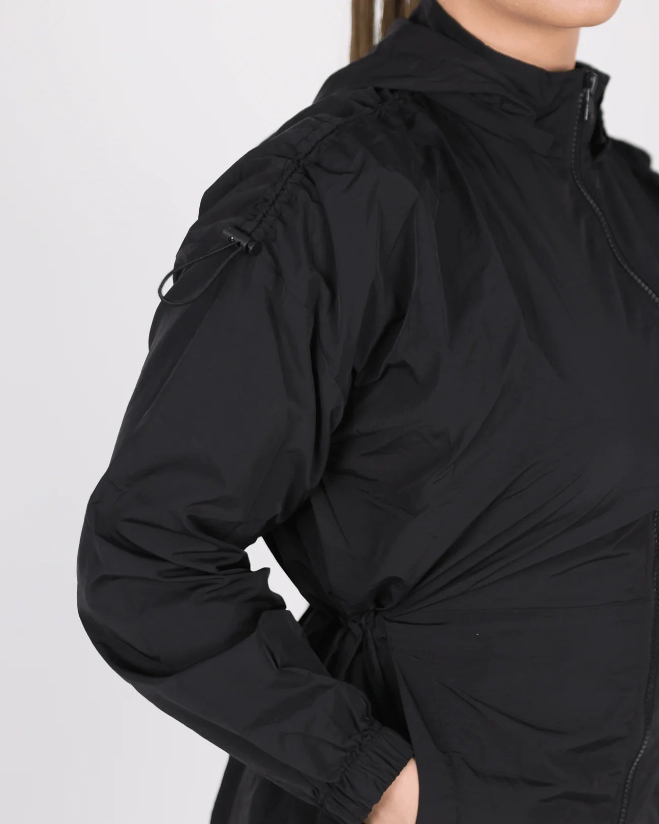 Black jacket worn by a person on a light gray background